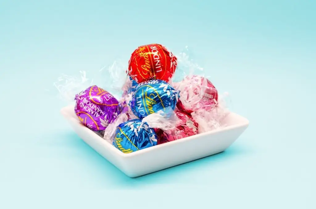 red and blue Lindt Lindor truffles on white ceramic tray