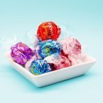 red and blue Lindt Lindor truffles on white ceramic tray