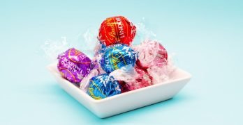 red and blue Lindt Lindor truffles on white ceramic tray